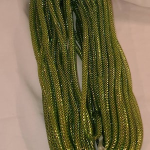 May include: A roll of green metallic mesh ribbon. The ribbon is shiny and has a fine, woven texture.