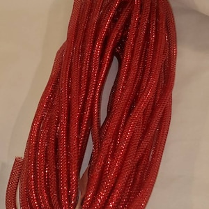 May include: A spool of red glitter cord. The cord is tightly wound and has a shiny, sparkly finish.