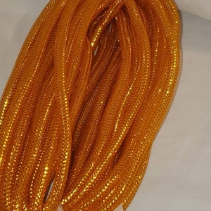 May include: A roll of gold metallic mesh ribbon. The ribbon is shiny and has a fine, even weave.