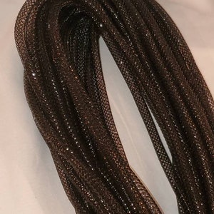 May include: A bundle of dark brown mesh tubing, tightly coiled and glistening. The mesh has a diamond pattern, and the overall effect is shiny and textured. The material appears to be flexible and suitable for crafts or decorative purposes.