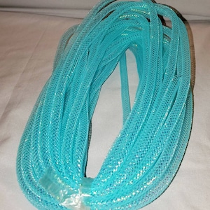 May include: A roll of turquoise iridescent mesh ribbon. The ribbon is made of a fine, delicate mesh fabric with a shimmering iridescent finish.