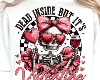May include: White sweatshirt with a pink and black graphic design featuring a skeleton holding a glass of wine and a heart-shaped balloon. The text "Dead inside but it's Valentine" is printed on the sweatshirt.