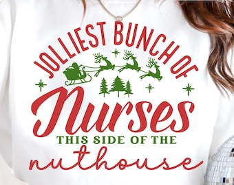May include: White sweatshirt with red text that reads "Jolliest Bunch of Nurses This Side of the Nuthouse". The text is surrounded by a circle with a green Christmas tree and a red and white Santa Claus in a sleigh with reindeer.