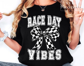 Może przedstawiać: Czarny T-shirt z białym napisem "Race Day Vibes" i kokardą w kratkę.