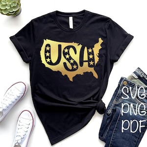 May include: A black t-shirt with a gold outline of the United States map. The word "USA" is inside the map with stars around it.