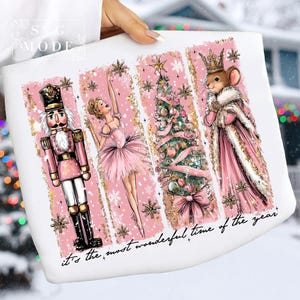 May include: White fabric featuring a pink and gold design with a Nutcracker, ballerina, Christmas tree, and mouse king. The text "it's the most wonderful time of the year" is at the bottom.