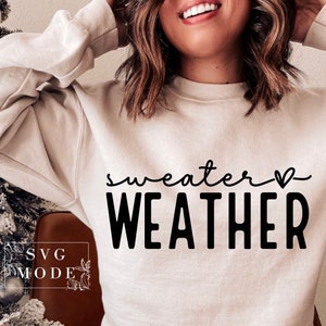May include: A white sweatshirt with the text "sweater weather" in black lettering and a small heart symbol.