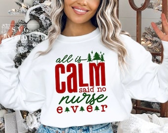 Puede incluir: Sudadera blanca con el texto "all is CALM said no nurse EVER" en rojo y verde, con gráficos de árboles de Navidad. Un diseño humorístico para enfermeras, ideal para la temporada festiva.