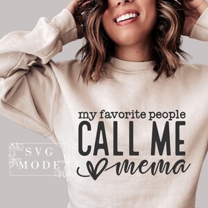 May include: A light beige sweatshirt with the text "my favorite people CALL ME mema" in black lettering with a heart graphic.