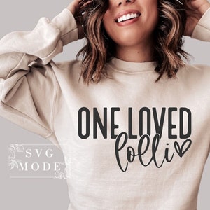 May include: A beige sweatshirt with the text "ONE LOVED lolli" in black with a small heart next to the word "lolli".