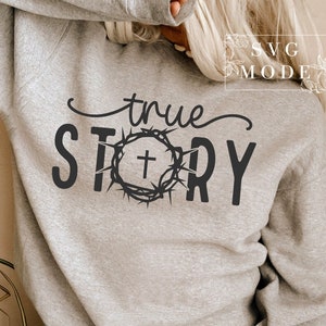 May include: Gray sweatshirt with the text "true story" in black lettering. A crown of thorns with a cross inside is centered between the words.