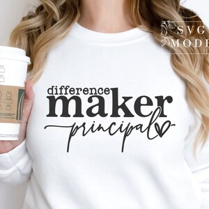 May include: White sweatshirt with black text that reads "difference maker principal" with a heart symbol.