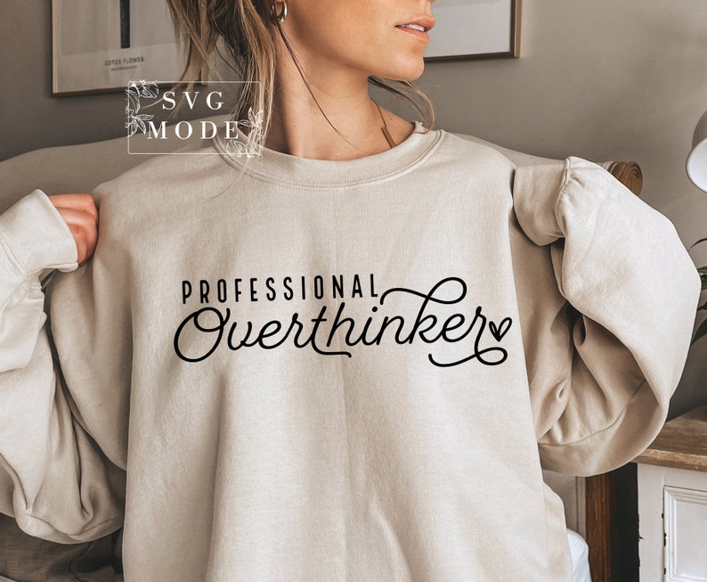 May include: A beige sweatshirt with the text "PROFESSIONAL Overthinker" in black cursive lettering with a small heart.