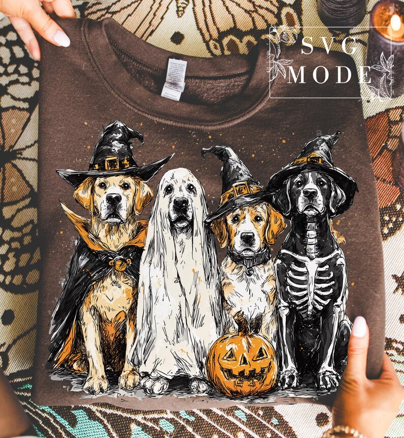 May include: Brown sweatshirt featuring a Halloween-themed graphic of four dogs dressed in costumes. One dog is a ghost, another wears a skeleton costume, and the others are in witch costumes. A carved pumpkin is in front of one dog.