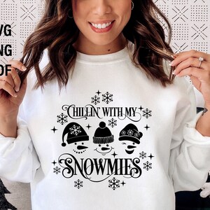 May include: White sweatshirt with a black graphic design featuring three snowmen and the text "Chillin' with my snowmies".