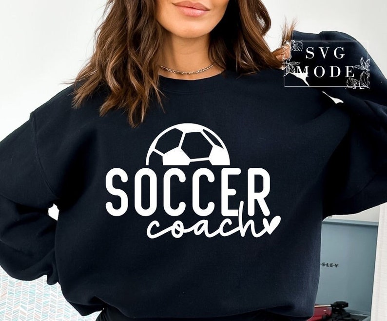 May include: Black sweatshirt with white text that reads "Soccer Coach" and a white football graphic.