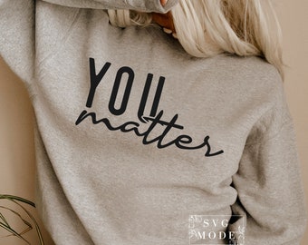 Könnte beinhalten: Ein grauer Pullover mit dem Aufdruck "YOU matter" in Schwarz.