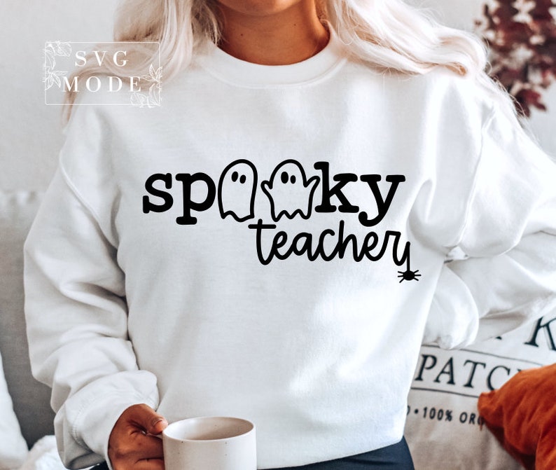 May include: White sweatshirt with black text that reads "spooky teacher" with three ghost silhouettes and a spider graphic.