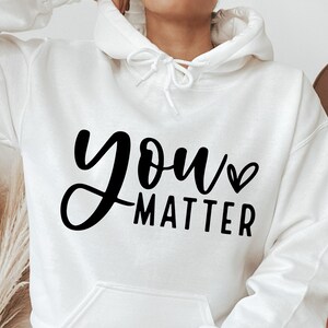 May include: White hoodie with black text that says "you matter" with a small heart symbol.