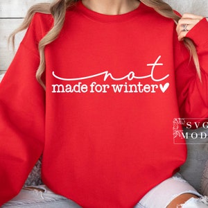 May include: Red sweatshirt with white text that reads "not made for winter" with a small heart symbol.