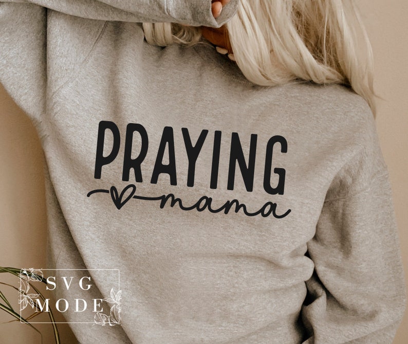 May include: A gray sweatshirt with the text "Praying mama" in black lettering with a small heart symbol.