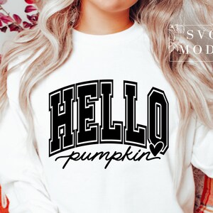 Może przedstawiać: Biała bluza z czarnym napisem "HELLO pumpkin" z małym czarnym sercem.