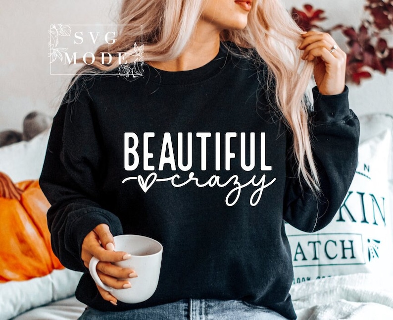 Pode incluir: Camisola de moletom preta com texto branco que diz "BEAUTIFUL crazy" com um s&iacute;mbolo de cora&ccedil;&atilde;o entre as palavras.