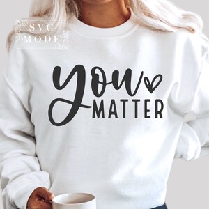 May include: White sweatshirt with black text that reads "you matter" with a small heart symbol.