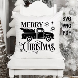 May include: White pillow with black text that reads "Merry Christmas" and a black silhouette of a pickup truck with a Christmas tree in the bed.