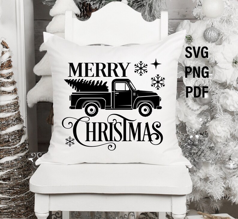 May include: White pillow with black text that reads "Merry Christmas" and a black silhouette of a pickup truck with a Christmas tree in the bed.
