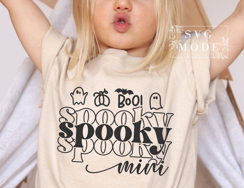 Puede incluir: Una camiseta beige para ni&ntilde;os peque&ntilde;os con un gr&aacute;fico negro que dice "Spooky mini" con un fantasma, una calabaza y un murci&eacute;lago.
