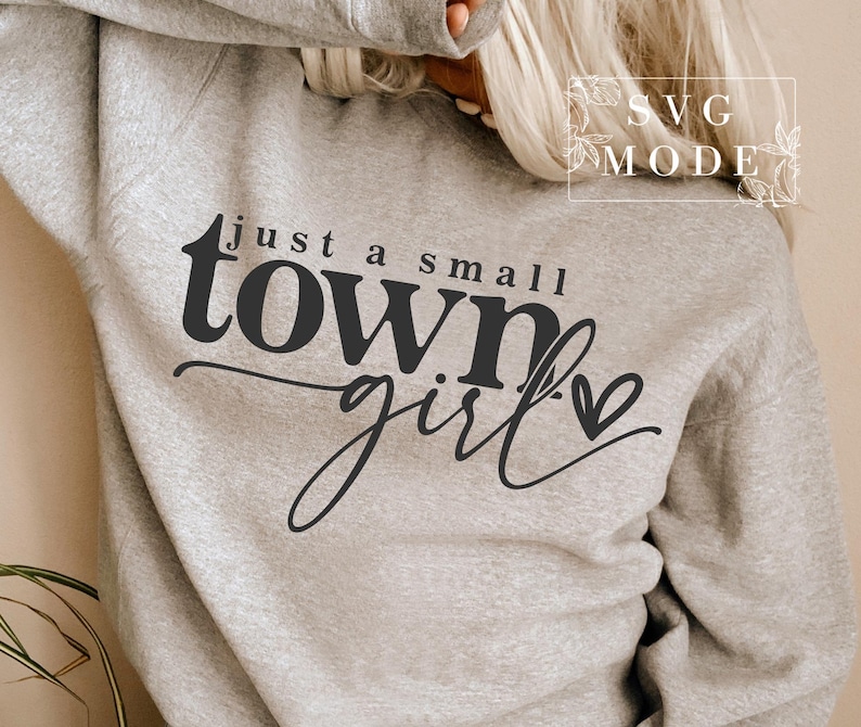 May include: A gray sweatshirt with the text "just a small town girl" in black lettering with a small heart.