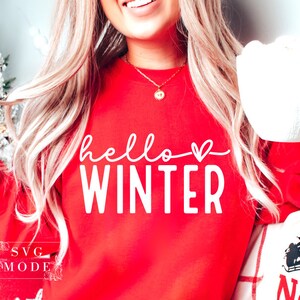 May include: A red sweatshirt with the text "hello winter" in white with a small heart after the word "hello".