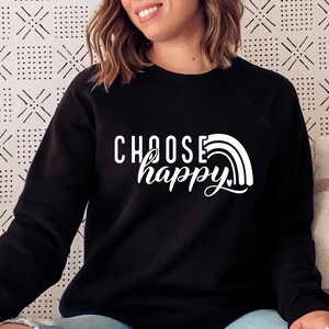 May include: Black sweatshirt with white text that reads "Choose happy" and a rainbow graphic.