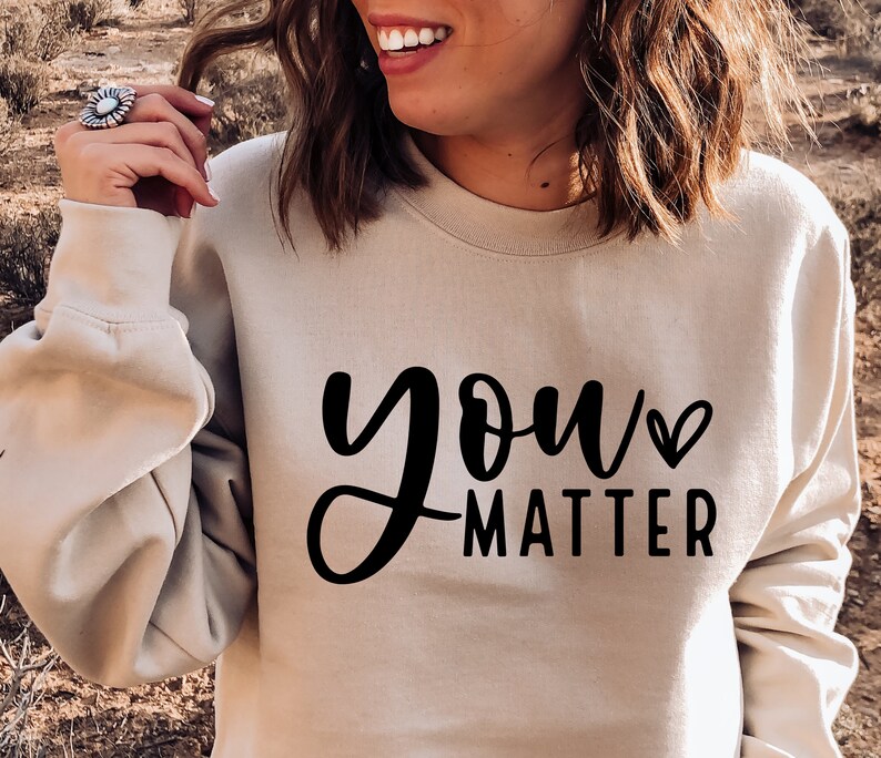 May include: A beige sweatshirt with the text "you matter" in black lettering with a small heart symbol.