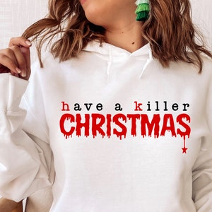 May include: White hooded sweatshirt with the text "have a killer CHRISTMAS" in red and black. The word "CHRISTMAS" has a dripping blood effect. A red star is at the end of the word "CHRISTMAS".