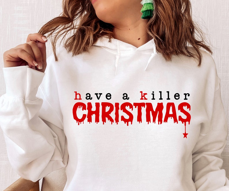 May include: White hooded sweatshirt with the text "have a killer CHRISTMAS" in red and black. The word "CHRISTMAS" has a dripping blood effect. A red star is at the end of the word "CHRISTMAS".