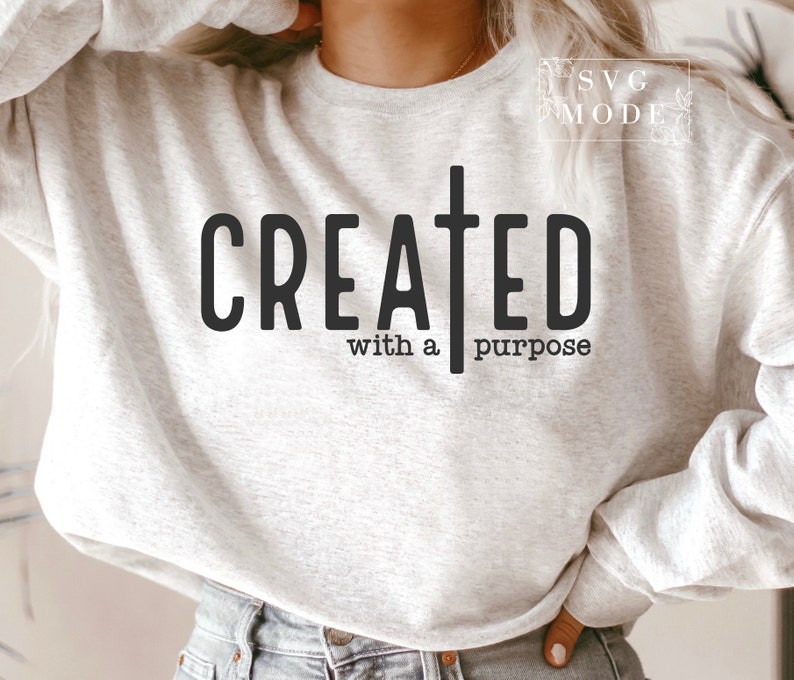 May include: A gray sweatshirt with the text "CREATED with a purpose" and a cross graphic.