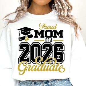 Puede incluir: Sudadera blanca con el texto "Proud Mom of a 2026 Graduate" en negro y dorado. El dise&ntilde;o incluye un birrete, un diploma y el a&ntilde;o 2026, celebrando a un futuro graduado.