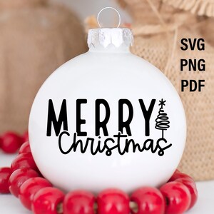 Puede incluir: Una bola de Navidad blanca con las palabras "MERRY Christmas" en escritura negra y un &aacute;rbol de Navidad estilizado. La bola est&aacute; rodeada por una cadena de cuentas rojas. La imagen tambi&eacute;n incluye el texto "SVG PNG PDF".