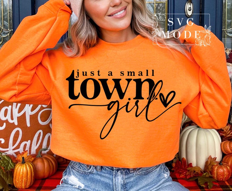 May include: Orange sweatshirt with the text "just a small town girl" in black lettering with a small heart.