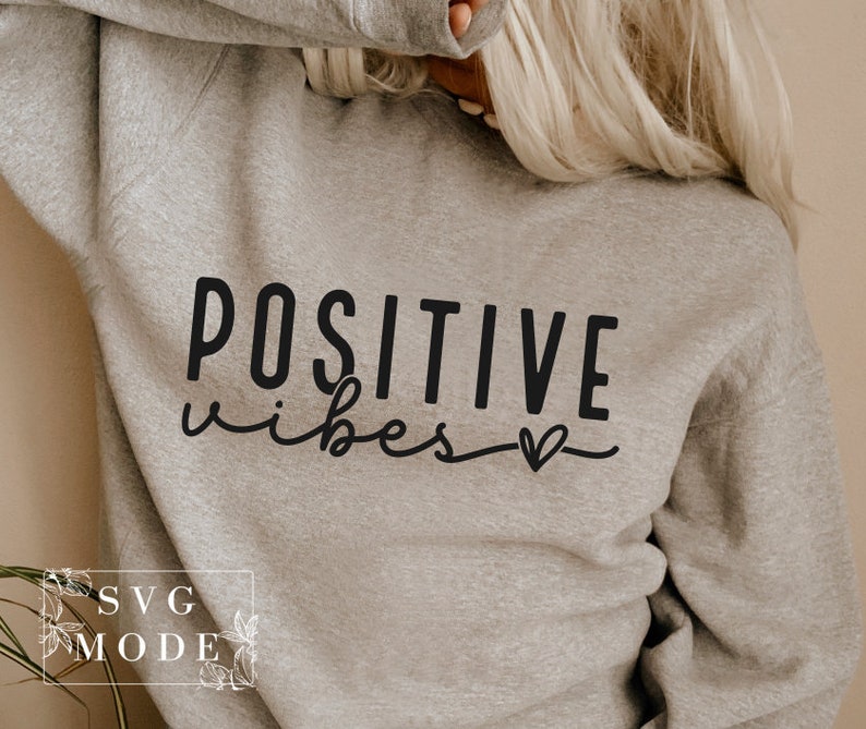 Peut inclure: Un sweat-shirt gris avec le texte "POSITIVE vibes" en lettres noires et un petit symbole de c&oelig;ur.