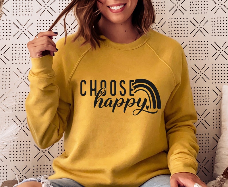 May include: A mustard yellow sweatshirt with the text "CHOOSE happy" in black lettering with a rainbow graphic.