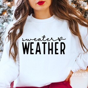 May include: White sweatshirt with black text that reads "sweater weather" with a small heart symbol.