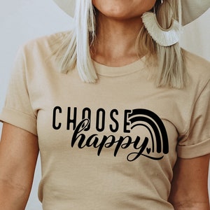 May include: A beige t-shirt with a black graphic that says "Choose happy" with a rainbow design.