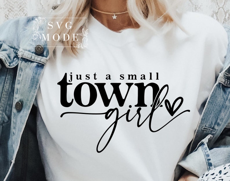 May include: White t-shirt with black text that reads "just a small town girl" with a small heart symbol.