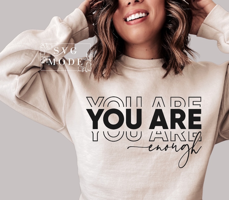 May include: A beige sweatshirt with the text "YOU ARE YOU ARE enough" printed in black.