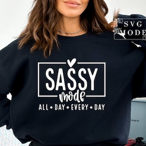 May include: Black sweatshirt with white text that reads "Sassy Mode" with a heart above the word "Sassy" and the words "All Day Every Day" below.