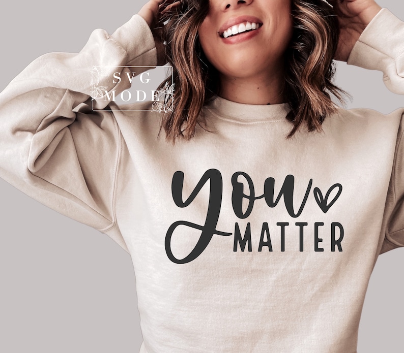 May include: A beige sweatshirt with the text "you matter" in black script with a small heart symbol.