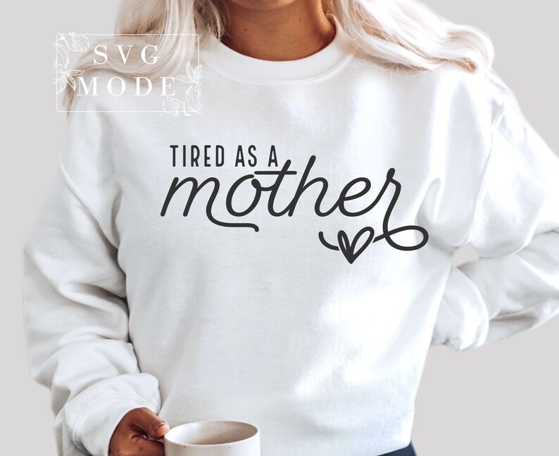 May include: White sweatshirt with the text "TIRED AS A mother" in black cursive lettering with a small heart at the end.